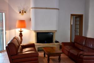 a living room with two couches and a television at Villa A Macchia, piscine et vue sur Bonifacio in Bonifacio