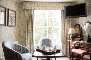 a living room with two chairs and a table with stuffed animals on it at The Eastbury & Spa in Sherborne