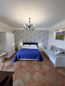 a bedroom with a bed and a couch and a chandelier at Villa Denise in Vico Equense