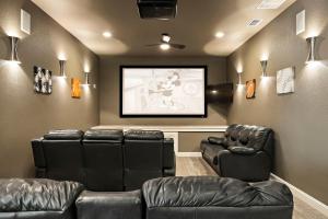 a movie room with leather chairs and a screen at Big Red Chicken Estate in Wimberley