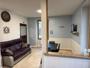 a living room with a couch and a chair at Gite la fontaine dargent in Aisy-sur-Armançon