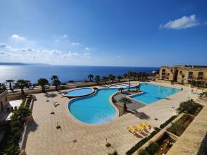 an overhead view of a swimming pool next to the ocean at Harba - An Escape at Fort Chambray in Għajnsielem