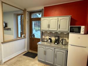 a kitchen with white cabinets and a white refrigerator at Gite la fontaine dargent in Aisy-sur-Armançon