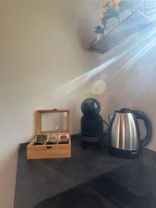 a counter with a coffee maker and a tea kettle at NOOR A-frame Sibiu in Gura Râului