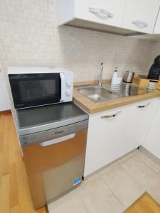 a kitchen with a microwave and a sink at SanRaffaele 117 - Ospedale & Metro Milano - Intero Appartamento in Vimodrone