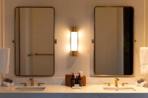 a bathroom with two sinks and two mirrors at Larch House in Whitefish