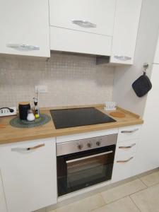 a kitchen with white cabinets and a stove top oven at SanRaffaele 117 - Ospedale & Metro Milano - Intero Appartamento in Vimodrone