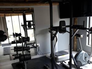 a gym with several tread machines and a treadmill at Haleys Guest House in Benoni