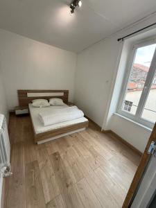 a white room with a bed and a window at Appart' Val 2 in Beaumont