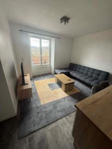 a living room with a couch and a table at Appart' Val 2 in Beaumont