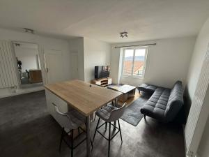 a living room with a table and a couch at Appart' Val 2 in Beaumont