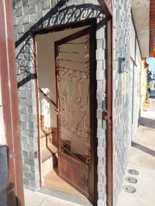 a brown door in a brick building with a brick wall at Bem Estar no Bom Ap 1 in Arapiraca