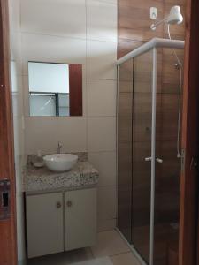 a bathroom with a sink and a glass shower at Bem Estar no Bom Ap 1 in Arapiraca
