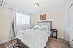a white bedroom with a bed and a window at Hampton Beach OCEAN FRONT Condo at the Surf in Hampton