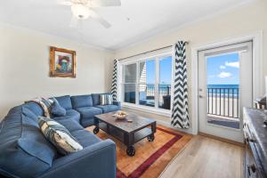 a living room with a blue couch and a table at Hampton Beach OCEAN FRONT Condo at the Surf in Hampton