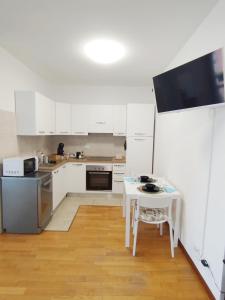 a kitchen with white cabinets and a white table at SanRaffaele 117 - Ospedale & Metro Milano - Intero Appartamento in Vimodrone