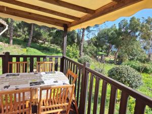 a wooden deck with a table and chairs at Chalet Horizon Mer in Conca