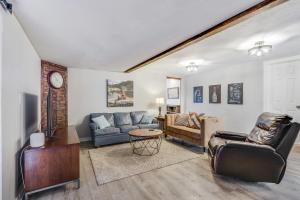 a living room with two couches and a clock at Bungalow on the Bluff in Fischer +19 photos