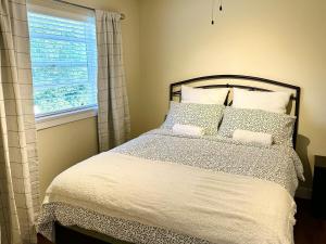 a bedroom with a large bed with a window at Sunny 1BR by Galloping Goose in Victoria