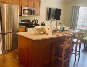 a kitchen with a kitchen island with a stainless steel refrigerator at Sunny 1BR by Galloping Goose in Victoria +9 photos