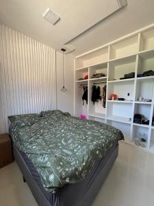 a bedroom with a bed and white shelves at Casa Aurora Provetá - Ilha Grande in Angra dos Reis