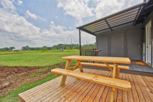 a wooden picnic table on a deck with a building at Blue Jay Getaway in Blanco