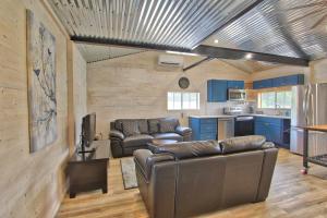 a living room with couches and a kitchen at Blue Jay Getaway in Blanco