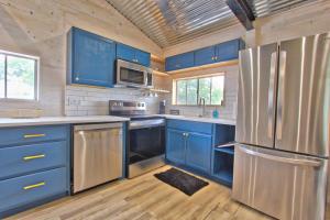 a kitchen with blue cabinets and a stainless steel refrigerator at Blue Jay Getaway in Blanco +17 photos