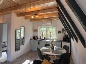 a kitchen with a table and chairs in a room at NOOR A-frame Sibiu in Gura Râului