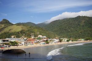 a beach with a group of people in the water at Casa Aurora Provetá - Ilha Grande in Angra dos Reis