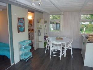 a kitchen and dining room with a table and chairs at Chalet Zen dans les landes in Castets