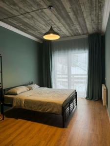 a bedroom with a bed and a large window at Apartment MILU in Mestia