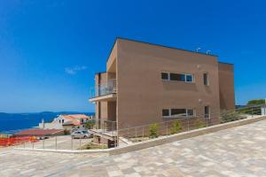 a large brown building with a parking lot at Villa Ilenia in Murter