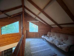 a living room with a couch and two windows at Pangui Lodge in Las Trancas