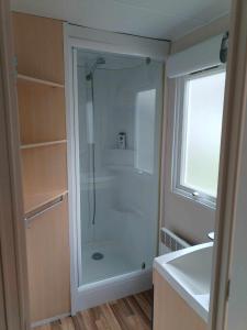 a bathroom with a shower with a glass door at MOBIL-HOME n 95 in Barrême +8 photos