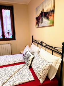 a bedroom with two beds with pillows at Casa Raggio di Sole in Toscolano Maderno +9 photos