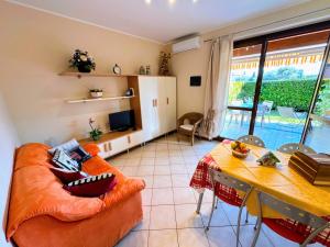 a living room with an orange couch and a table at Casa Raggio di Sole in Toscolano Maderno