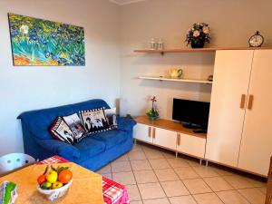 a living room with a blue couch and a tv at Casa Raggio di Sole in Toscolano Maderno