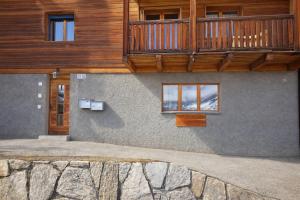 a house with a balcony on the side of it at Maison d'Hortense - Chalet le Renard in Hérémence