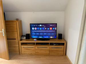 a flat screen tv sitting on top of a wooden cabinet at Yimi Ferienwohnung in Grafenwiesen
