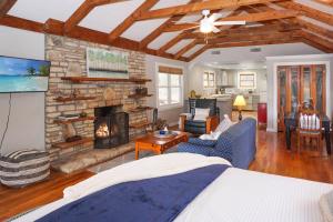 a living room with a stone fireplace and a bed at Burnett Ranch Cabins- Prickly Pear in Wimberley