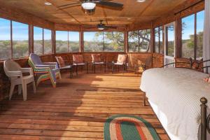 a screened in porch with a bed and chairs at Burnett Ranch Cabins- Prickly Pear in Wimberley