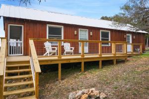 a large deck in front of a red house at Burnett Ranch Cabins- Prickly Pear in Wimberley