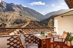 a balcony with a table and chairs and mountains at Apto rurales y habitaciones MONTE CAORU - CABRALES apartahotel in Arenas de Cabrales +33 photos
