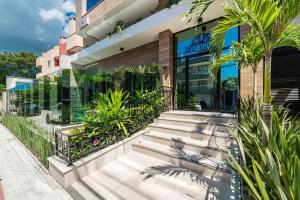 a building with stairs and plants in front of it at Apartamento 2 suítes C/Piscina in Bombinhas