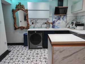 a kitchen with a dishwasher and a mirror on the wall at Secret Garden Suite in Gloucestershire