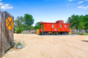 a red train car parked next to a fence at Caboose on the Square in Wimberley
