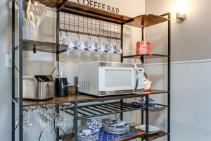 a kitchen with a microwave on a shelf with dishes at Warren County Launchpad: Pet-Friendly Lebanon Apt in South Lebanon +16 photos