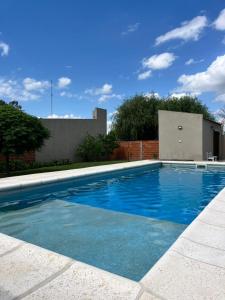 a swimming pool with blue water in a yard at La casita in Saladillo