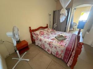 a bedroom with a bed and a fan on the floor at kolaille chambre HOTE numéro 42 in Saint-Pierre
